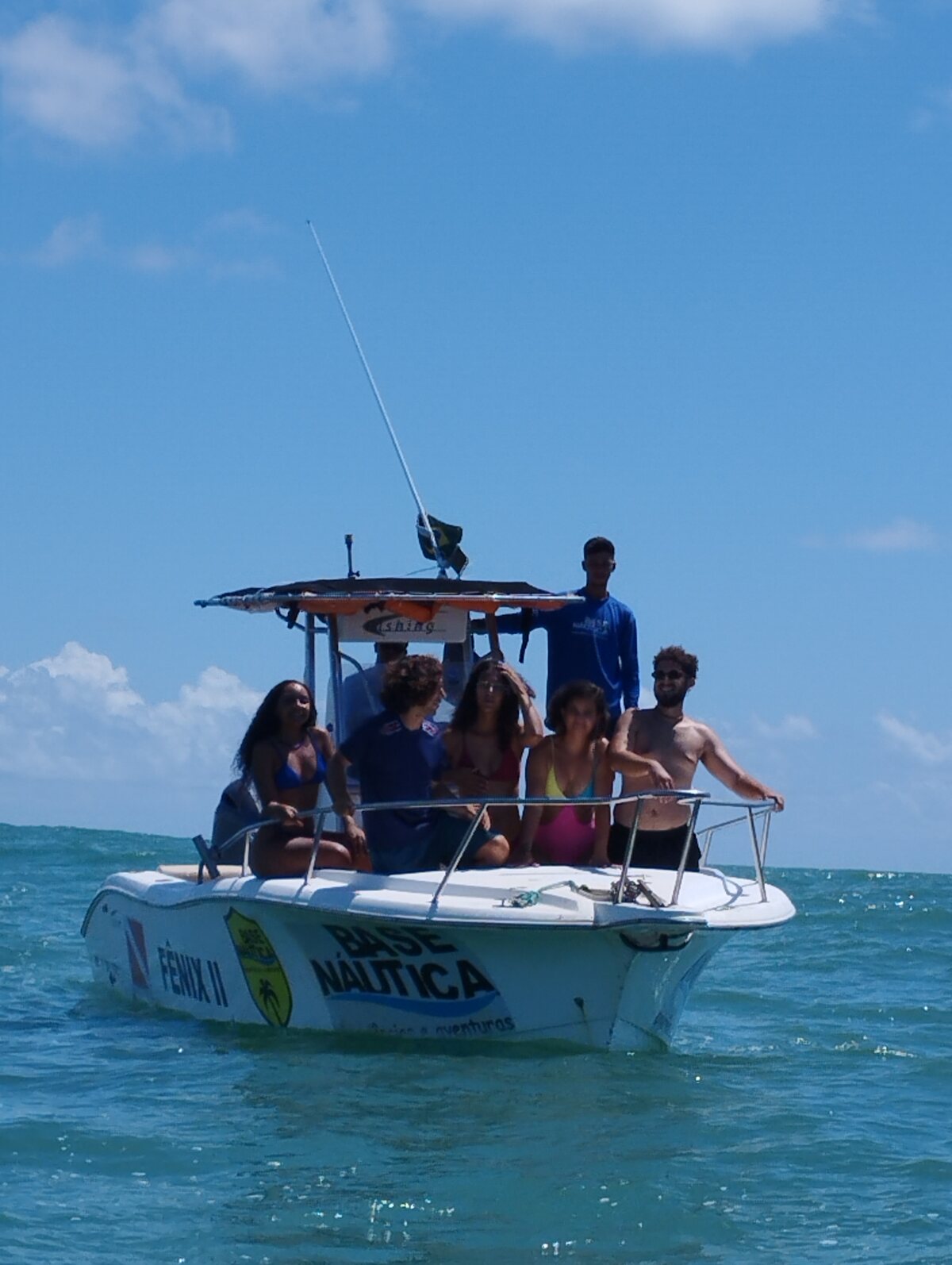 Grupo de passageiros a bordo da lancha Fênix II da Base Náutica em alto-mar