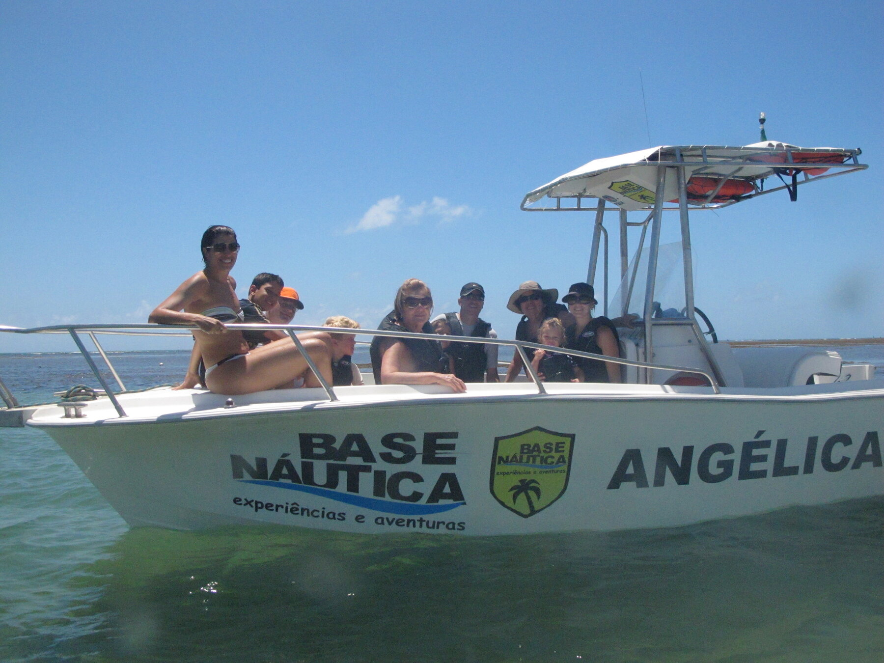 Grupo de turistas sorrindo a bordo da lancha da Base Náutica em Praia do Forte